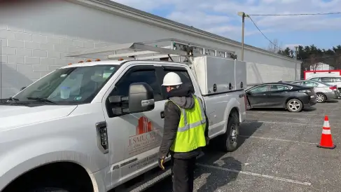 Team member and J Smucker Contracting truck preparing for commercial roof repair